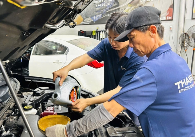 Kỹ thuật viên thay nhớt xe ô tô và kiểm tra lọc dầu tại gara